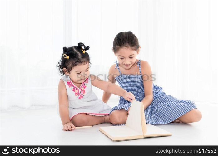 Happy two sister drawing in sketch book together at home or nursery. People lifestyle and kids play. Education and Children concept. Diverse ethnicity and ages. Back to school theme