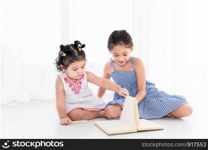 Happy two sister drawing in sketch book together at home or nursery. People lifestyle and kids play. Education and Children concept. Diverse ethnicity and ages. Back to school theme