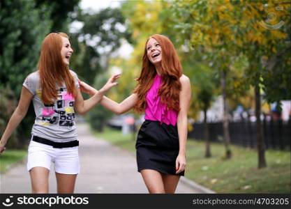 Happy two young women in autumn city