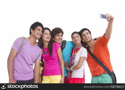 Happy university friends taking self-portrait with smart phone on white background