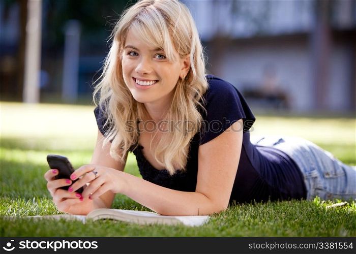 Happy university student sending a text message