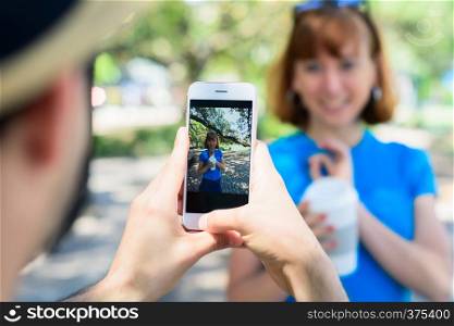 Happy urban young couple taking photo with smartphone camera. Love concept.