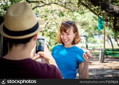 Happy urban young couple taking photo with smartphone camera. Love concept.