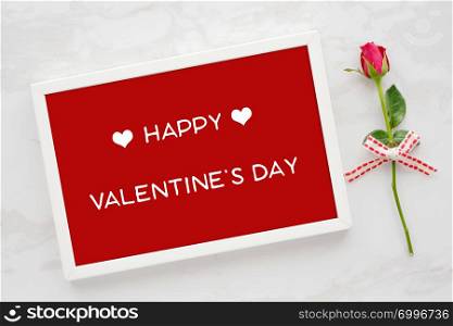 Happy valentine?s day card in white wooden frame and red rose on white marble background, banner, flat lay