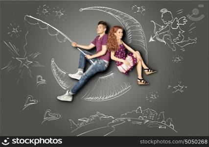 Happy valentines love story concept of a romantic couple fishing on a moon with a star on a hook against chalk drawings background of a night sky and a Cupid.