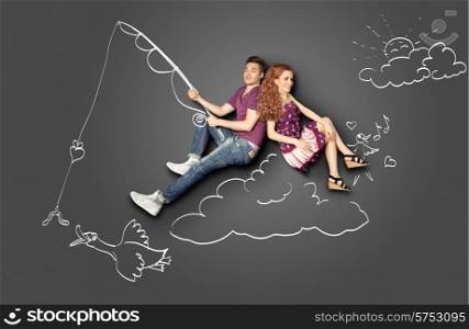 Happy valentines love story concept of a romantic couple fishing on a cloud with a bait on a hook against chalk drawings background.