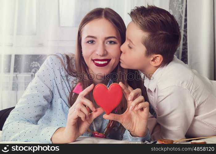 Happy Valentines or mother day. Happy Valentines Day or Mother day. Young boy spend time with her mum and celebrate with gingerbread heart cookies on a stick.