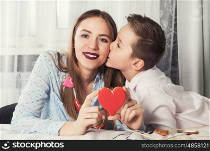 Happy Valentines or mother day. Happy Valentines Day or Mother day. Young boy spend time with her mum and celebrate with gingerbread heart cookies on a stick.