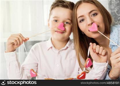 Happy Valentines or mother day. Happy Valentines Day or Mother day. Young boy spend time with her mum and celebrate with gingerbread heart cookies on a stick.