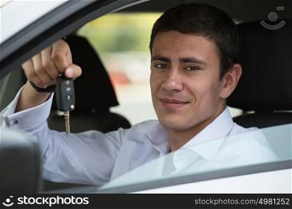 Happy vehicle buyer inside his new car with car key