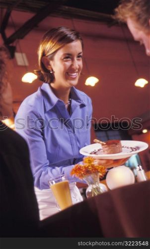 Happy Waitress Serving Dessert