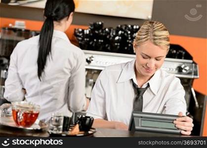 Happy waitresses working at cafe in uniform