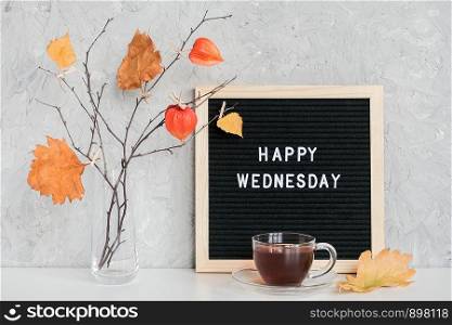 Happy Wednesday text on black letter board and bouquet of branches with yellow leaves on clothespins in vase on table Template for postcard, greeting card Concept Hello autumn Wednesday.. Happy Wednesday text on black letter board and bouquet of branches with yellow leaves on clothespins in vase on table Template for postcard, greeting card Concept Hello autumn Wednesday