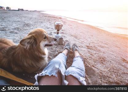 happy weekend by the sea - girl with a dog in a tent on the beach at dawn. Ukrainian landscape at the Sea of Azov, Ukraine