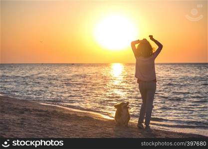 happy weekend by the sea - girl with a dog on the beach. Ukrainian landscape at the Sea of Azov, Ukraine