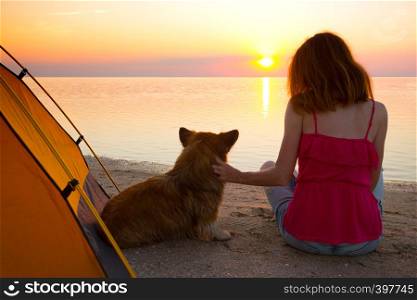 happy weekend by the sea - girl with a dog on the beach at sunset. Ukrainian landscape at the Sea of Azov, Ukraine