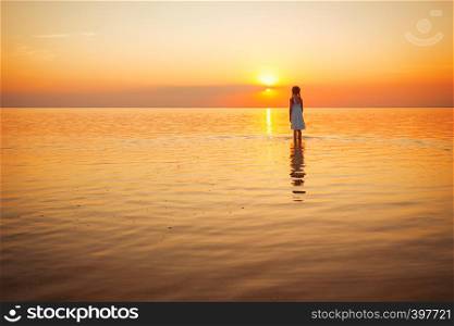 happy weekend by the sea - little girl looks at the sunset at the sea. Ukrainian landscape at the Sea of Azov, Ukraine