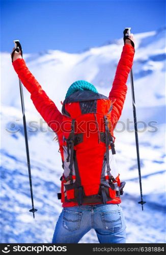 Happy winner of winter sport games, back side of cheerful skier with raised up hands enjoying competition, wintertime activities