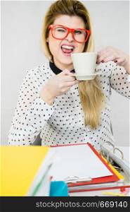 Happy woman at office drinking hot coffee or tea enjoying her break time during work. Job relax.. Happy woman at office drinking hot coffee