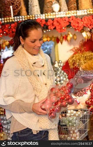 Happy woman buying Christmas decoration in plastic boxes