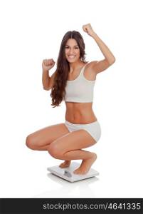 Happy woman celebrating her new weight on a scale isolated on a white background