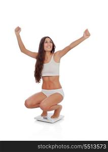 Happy woman celebrating her new weight on a scale isolated on a white background