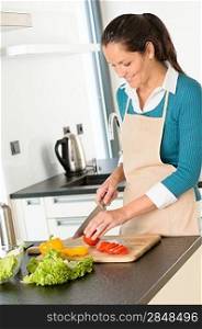 Happy woman cutting tomato kitchen vegetables preparing salad food
