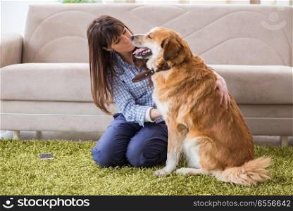 Happy woman dog owner at home with golden retriever