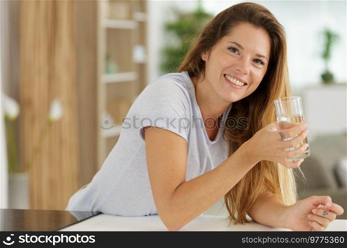 happy woman drinking fresh water at home