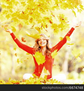 Happy woman drop up leaves in autumn park. Happy autumn woman