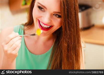 Happy woman eating delicious gourmet sweet cream cake cupcake with fruits. Glutton girl having breakfast in kitchen. Appetite and gluttony concept.. Woman eating cream cake with fruits. Gluttony.
