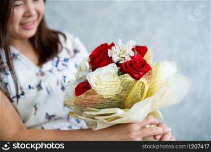 Happy woman gets rose bouquet gift from her boyfriend on Valentines day. Couple love lifestyle concept.