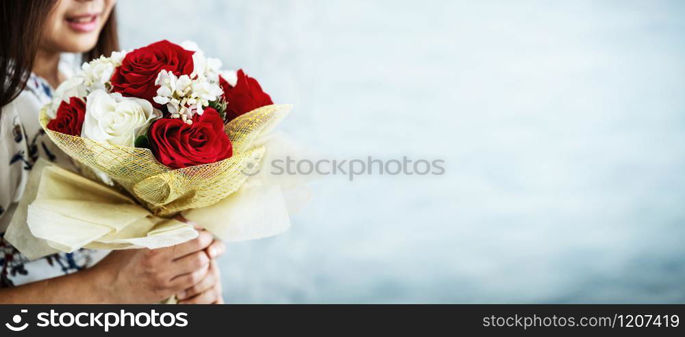 Happy woman gets rose bouquet gift from her boyfriend on Valentines day. Couple love lifestyle concept.