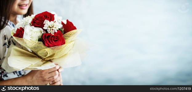 Happy woman gets rose bouquet gift from her boyfriend on Valentines day. Couple love lifestyle concept.