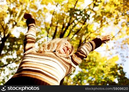 Happy woman having fun in autumn park. Happy autumn woman