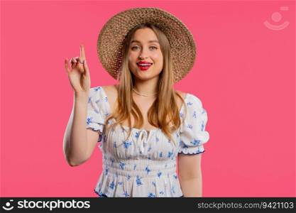 Happy woman having idea eureka moment, pointing finger up on pink background. Clever lady showing answer gesture or remembered what she forgot, memory concept. High quality. Breakthrough creative idea - happy woman having eureka moment,pointing finger up