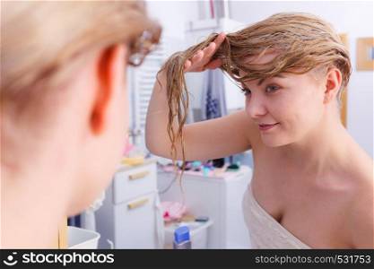 Happy woman having wet blonde hair. Positive clean female after taking a shower feeling clean and relaxed.. Woman with wet blonde hair