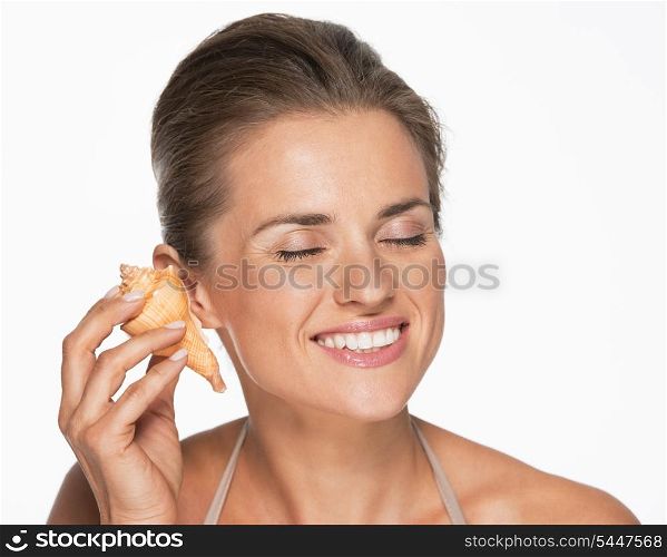 Happy woman hearing waves in sea shell