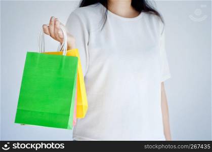 happy woman holding colorful shopping bags with white background