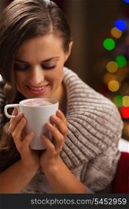 Happy woman holding cup of hot chocolate with marshmallows