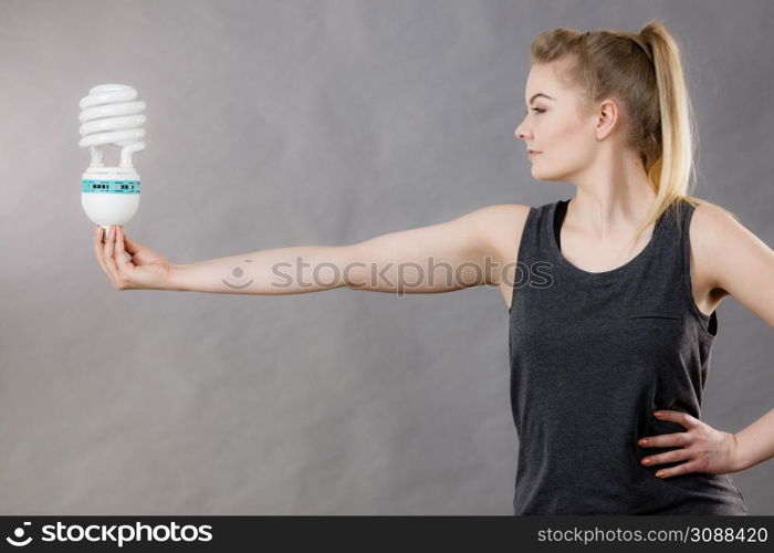 Happy woman holding eco modern light bulb. Innovation technology, power saving concept.. Woman holding eco modern light bulb