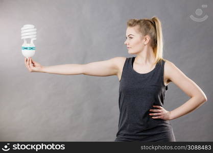 Happy woman holding eco modern light bulb. Innovation technology, power saving concept.. Woman holding eco modern light bulb