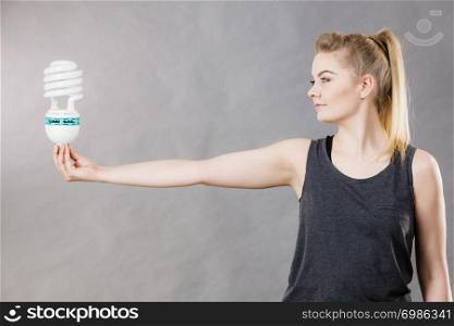 Happy woman holding eco modern light bulb. Innovation technology, power saving concept.. Woman holding eco modern light bulb