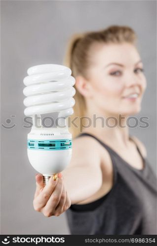 Happy woman holding eco modern light bulb. Innovation technology, power saving concept.. Woman holding eco modern light bulb