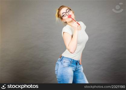 Happy woman holding fake lips on stick having fun. Photo and carnival funny accessories concept.. Happy woman holding fake lips on stick