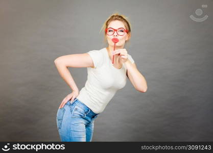 Happy woman holding fake lips on stick having fun. Photo and carnival funny accessories concept.. Happy woman holding fake lips on stick