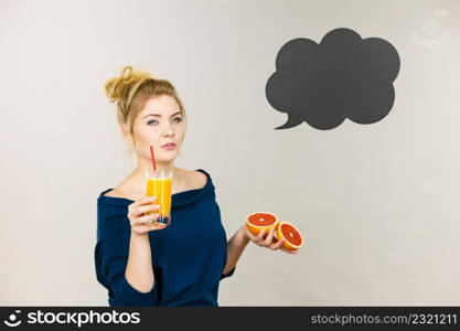 Happy woman holding fresh orange grapefruit juice. Healthy fruit drink smoothies concept, black thinking or speech bubble next to her.. Happy woman holding fresh orange juice