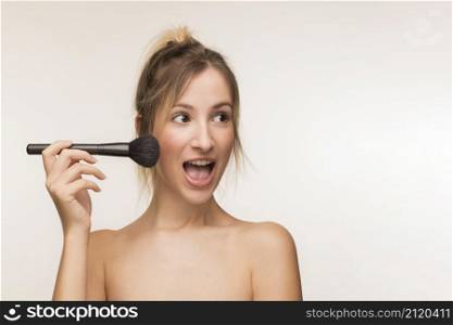 happy woman holding makeup brush