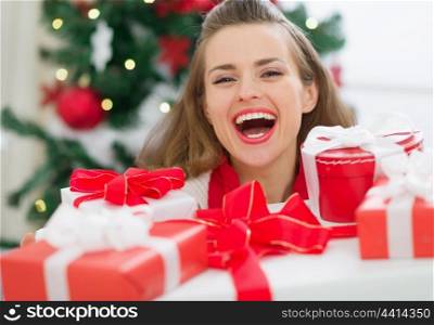 Happy woman holding stack of Christmas present boxes