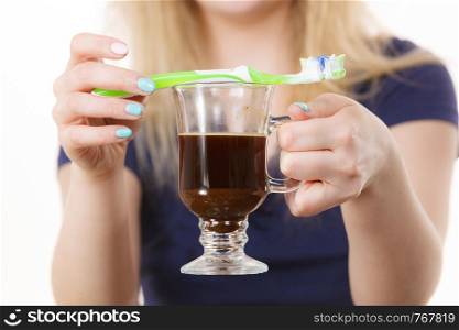 Happy woman holding toothbrush and coffee going to brush her teeth after hot drink. Discoloration prevention.. Happy woman holding toothbrush and coffee